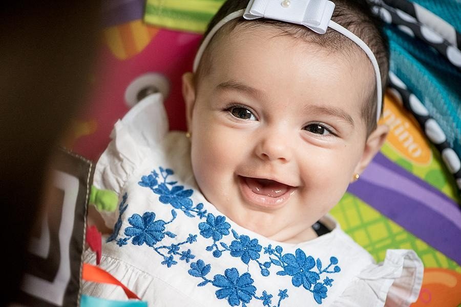 Close no rosto de um bebê sorrindo, resolvendo o fundo colorido